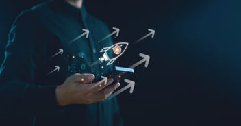 Person holding a smartphone with a glowing rocket and upward arrows, symbolizing business growth, digital transformation, and the key benefits of SAP Business One for scaling operations.