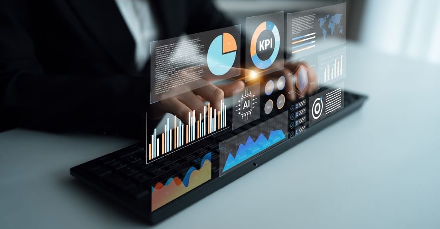 Close-up of a professional using a laptop with a holographic business intelligence dashboard displaying KPI metrics, AI analytics, bar charts, and performance graphs, representing data-driven enterprise decision-making and digital transformation.