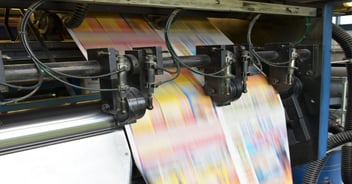 High-speed commercial printing press producing full-color print materials, illustrating production efficiency, cost considerations, and operations in a modern print manufacturing environment.
