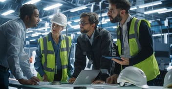 Manufacturing team reviewing SAP Business One deployment options on laptop in modern factory setting