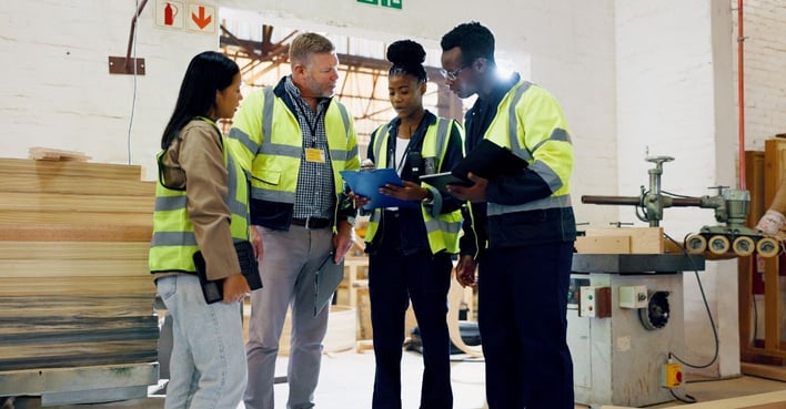 Manufacturing team reviewing production workflows and operational planning on the factory floor.