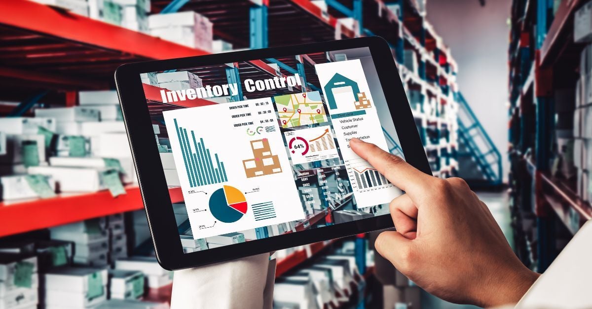 Warehouse employee using a tablet dashboard to monitor inventory levels, stock movement, and supply chain performance.