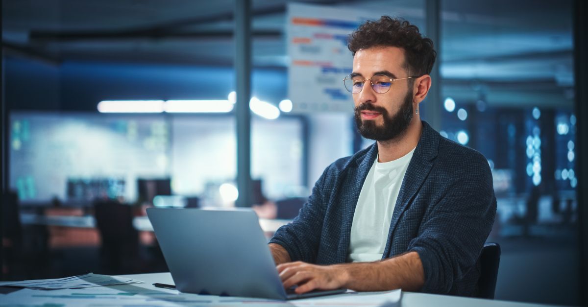 Professional working on a laptop in a modern office, analyzing data and business systems—representing ERP solutions like Dynamics NAV and Dynamics 365 Business Central.