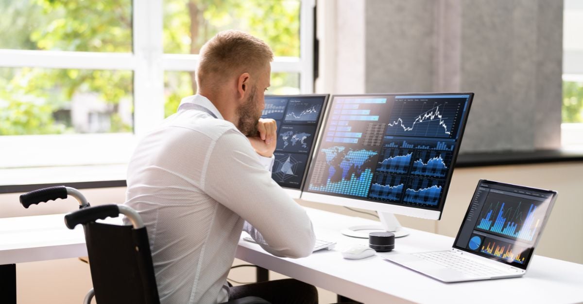 Man using multiple data dashboards to analyze ERP architecture and operating costs for business performance.