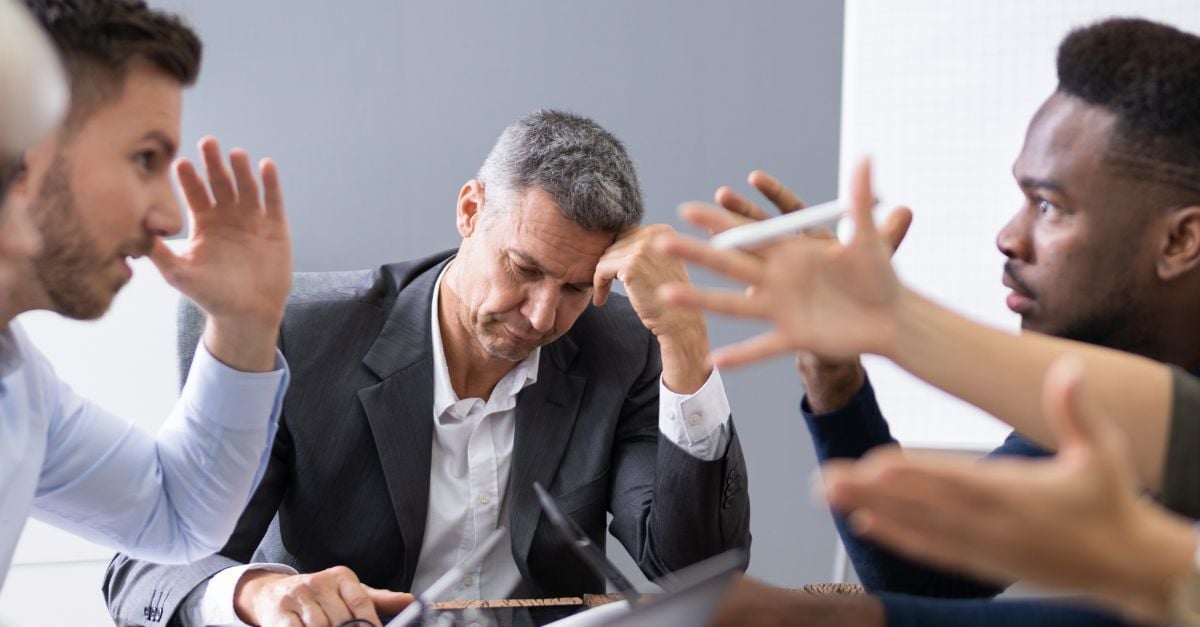Business leaders in a tense meeting, illustrating the frustration and communication challenges of ERP integration failures.