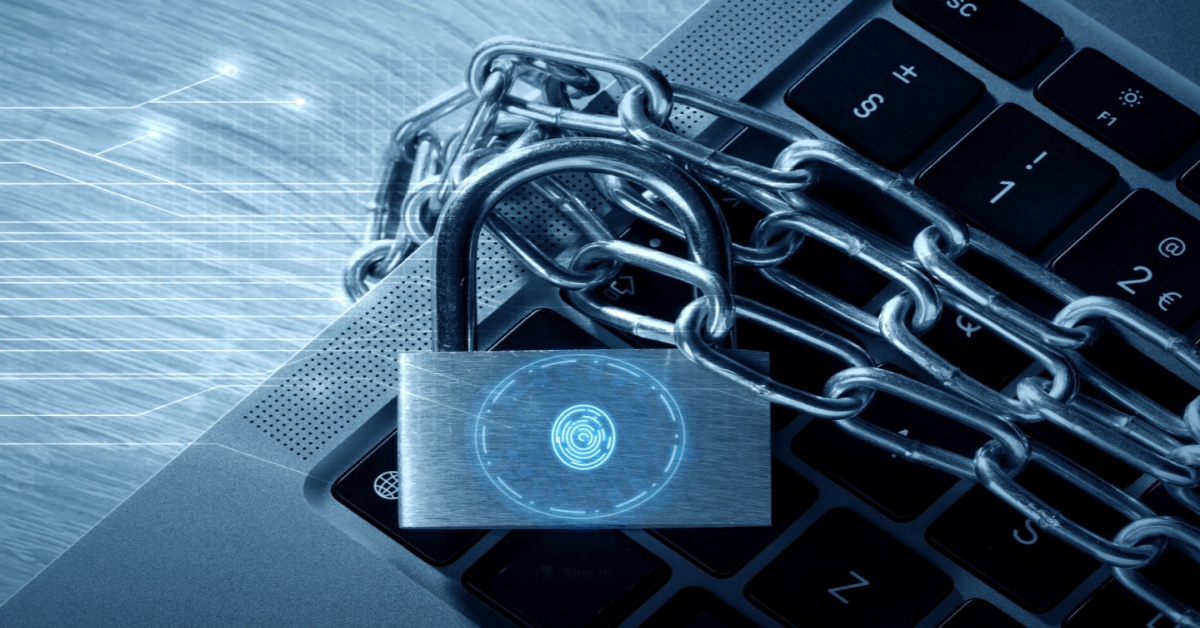 Laptop keyboard wrapped in metal chains with a digital padlock and fingerprint icon, representing cybersecurity threats, data protection, and security risks targeting ERP systems and supply chain operations.
